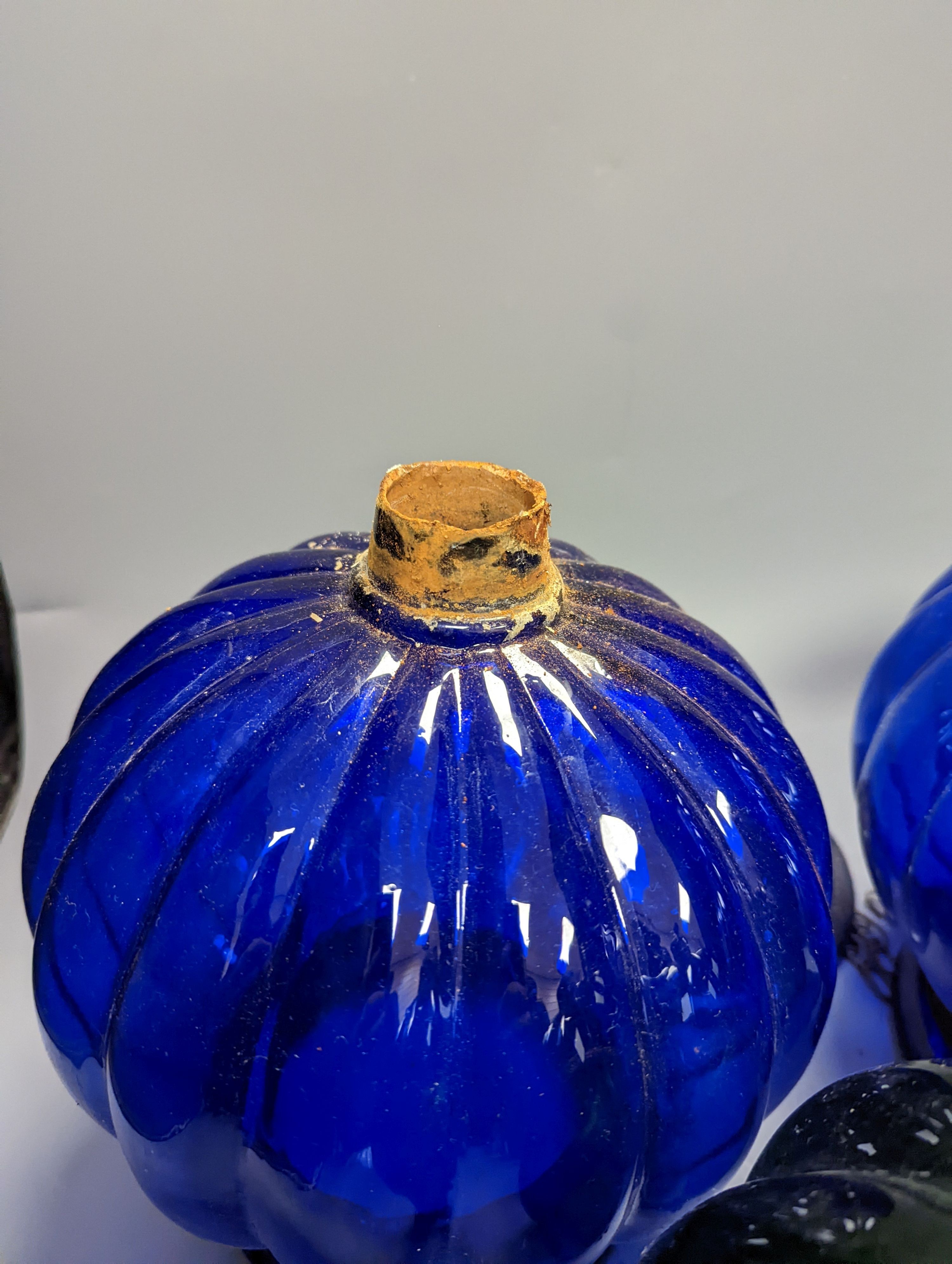 Three coloured glass pendant fluted globe shaped lamps - two blue, one green, 30 cms high.